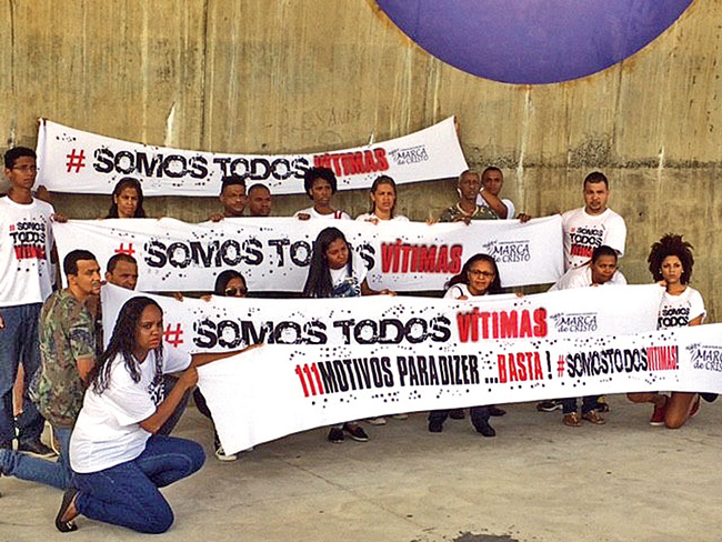 Jovens seguram faixas com os dizeres "Somos todos vtimas" e "111 motivos para dizer... Basta!"